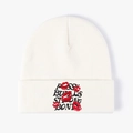 Off-white knit beanie featuring red lip embroidery and Buds Strong Bones text - White