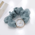 Macro shot of grey-blue fabric scrunchie strap watch with daisy motif on white dial - Aqua
