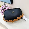 Detail of black pebbled leather camera bag with golden hardware and caramel wave strap - Black (Brown Strap)