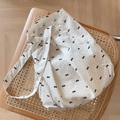 Flachbild der Baumwolltasche mit schwarzen Schleifenmustern auf einem Rattanstuhl - Schwarze Punkte Kleine Schleife