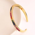 Detail van een gouden C-vormige open armband met micro-pave veelkleurige zirkonia - Goud