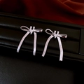 Close-up of silver bow earrings with sparkling zircons and long elegant metal tassels - Bow Tassel Stud Earrings (Silver Earring Post) / Silver
