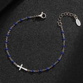 Detail of stainless steel cross bracelet with blue beads on black textured surface - Silver-Blue