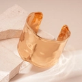 Detailed macro view of wide golden metal cuff with irregular hammered texture on stone - Gold (Eco-friendly)