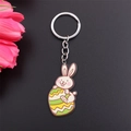 Easter keychain featuring a cute enamel rabbit holding a colorful egg on black background - Green Egg Rabbit