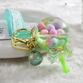 Macro shot of an acrylic lollipop keychain with colorful sequins and a green bow detail - Green