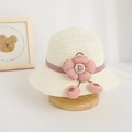 Dettaglio di cappello di paglia per bambini con grande fiore rosa e perline decorative - Cappello / crema