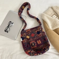 Close-up of ethnic pattern plush crossbody bag with miss bag label on fabric background - Ethnic