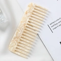Detail of beige marble pattern acetate hair comb with wide teeth for anti-static styling - Yellow Marble