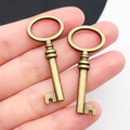 Mano che tiene due chiavi vintage a forma di cuore in bronzo antico per gioielli DIY - Chiave in Bronzo Antico 16x40mm