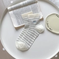 Calze bianche a righe grigie con ricamo COOL blu su tavolo in stile minimalista - Righe Grigie