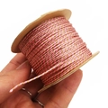 Hand holding pink and gold braided 1mm cord wound on a kraft paper coil roll - Approx. 1.0mm 40m / Pink
