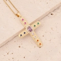 Golden hip hop cross necklace with colorful zircon stones on a beige textured stone base - Colorful