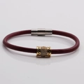 Dettaglio del bracciale in pelle rossa con ciondolo in zircone dorato e chiusura magnetica - Rosso vino/Oro