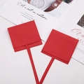 Red microfiber jewelry pouch with flap and drawstring closure on a white desk - Red