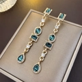 Detail of gold vintage earrings with emerald green gemstones and crystal tassels - Green Rhinestone Geometric Drop Earrings (HE6362)