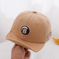 Dettaglio del cappellino bimbo kaki in cotone con patch lettera B e visiera corta - Cachi / 50cm 1-3 Anni