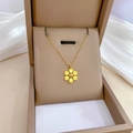 Dettaglio di un ciondolo a fiore dorato a sei petali dentro una scatola regalo marrone - Oro (J517 Oro)