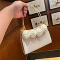 Detalle de las rosas de satén y las asas dobles de perlas en el elegante bolso de mano - Albaricoque
