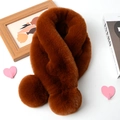Detail of soft brown faux fur scarf with pom-pom ball decoration on a white surface - Caramel color
