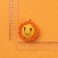 Close-up of 5cm handmade crochet sunflower keychain with orange petals and yellow center - Finished Little Sun Doll (6cm)