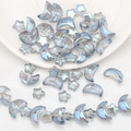 Detailed view of iridescent star and moon glass beads for DIY jewelry making - Semi-transparent Blue