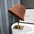 Brown crochet straw bucket hat with hollow knit design on a gold display stand - Honeycomb Caramel