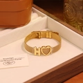 Vue détaillée d'un bracelet en maille dorée avec lettre H et pendentif coeur en coffret - Lettre H