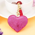 Primer plano de llavero corazón rosa con diamantes, campana dorada y borla rosa - Tono Dorado + Rosa Fucsia Oscuro