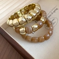Detail of three-piece amber resin and gold bead stretch bracelet set in a jewelry box - Coffee (3-Piece Set)