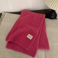 Thick rose red knitted scarf with vertical ribbed texture on beige rug with soft lighting - Rose Red