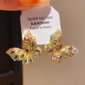 Gros plan de boucles d'oreilles papillon en argent doré avec des pierres colorées - Tige en Argent 925 - Design Papillon Coloré
