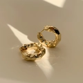 Dettaglio di orecchini a cerchio dorati con texture increspata e finitura lucida - 43# Fibbia per Orecchio - Oro