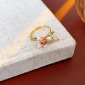 Anello floreale in smalto rosa placcato oro con foglie verdi su base beige ruvida - Anello-Oro-Rosa