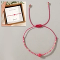 Detailansicht des rosa Januar-Geburtsstein-Perlenarmbands mit verstellbarer Kordel - Januar Geschenkbox Plus/Rosa/Granat