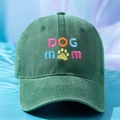 Close-up of DOG mom embroidery and yellow paw print on washed green cotton baseball cap - One Size / Dark Green