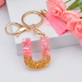 Pink resin letter U keychain with shell flakes, gold foil, and matching tassel pendant - Letter U
