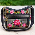 Black canvas crossbody bag with vibrant floral embroidery and tiered zippers - Red Lotus