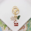 Close-up of golden Christmas keychain with Santa Claus, snowflake and Merry Christmas tag - Santa Snowflake Sign