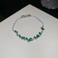Detailed macro shot of a silver tennis bracelet with emerald green zircon gemstones - Silver Green Waterdrop