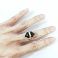 Detail of a minimalist gold ring featuring a hexagonal black crystal stone on a hand - Black Agate