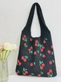 Detail of black knitted tote bag featuring red and green cherry patterns and integrated handle - Black
