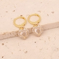 Close-up of gold-plated heart earrings with sparkling zircon stones on stone background - White Pearl Drop Earrings