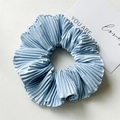 Detail of light blue pleated satin scrunchie with silky texture on a neutral background - Pleated Light Blue