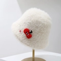 Detailed texture of white plush bucket hat with red cherry and button decorations - Beige