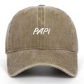 Macro detail of the white PAPI embroidery on a washed khaki cotton baseball cap - Khaki
