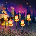 Solar powered Christmas garden stakes with five glowing Santa Claus figures for yard decor - Style 1