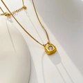 Detail of flower-shaped pendant with clear zircon and golden box chain on minimalist backdrop - Irregular Square Zirconia