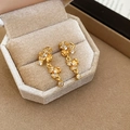 Nahaufnahme der 24K vergoldeten Blumenohrringe mit Zirkonia auf beige Samtstoff - Herzförmiger Dreiblättriger Hängestil (2# Sterling Silber Stift - Gold)
