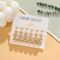 Set of golden spherical stud earrings in various sizes displayed on a fashion card - Ball Studs / Gold
